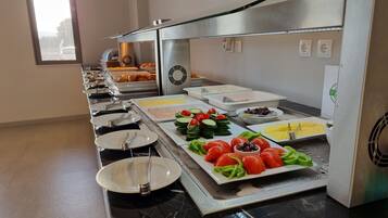 Una mesa de buffet con diversos alimentos y utensilios.