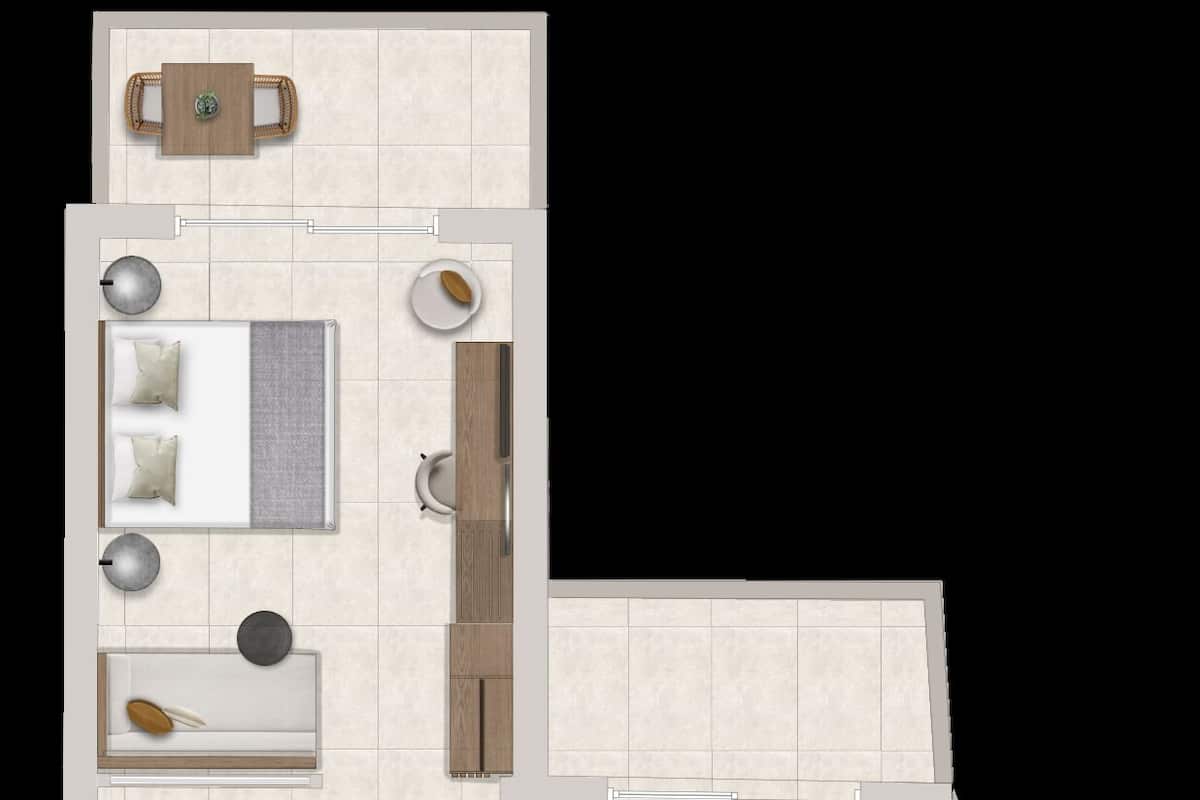 Un plan d’étage d’une chambre d’hôtel comprenant un lit, un coin salon avec une table et des chaises, une salle de bain et une petite kitchenette.