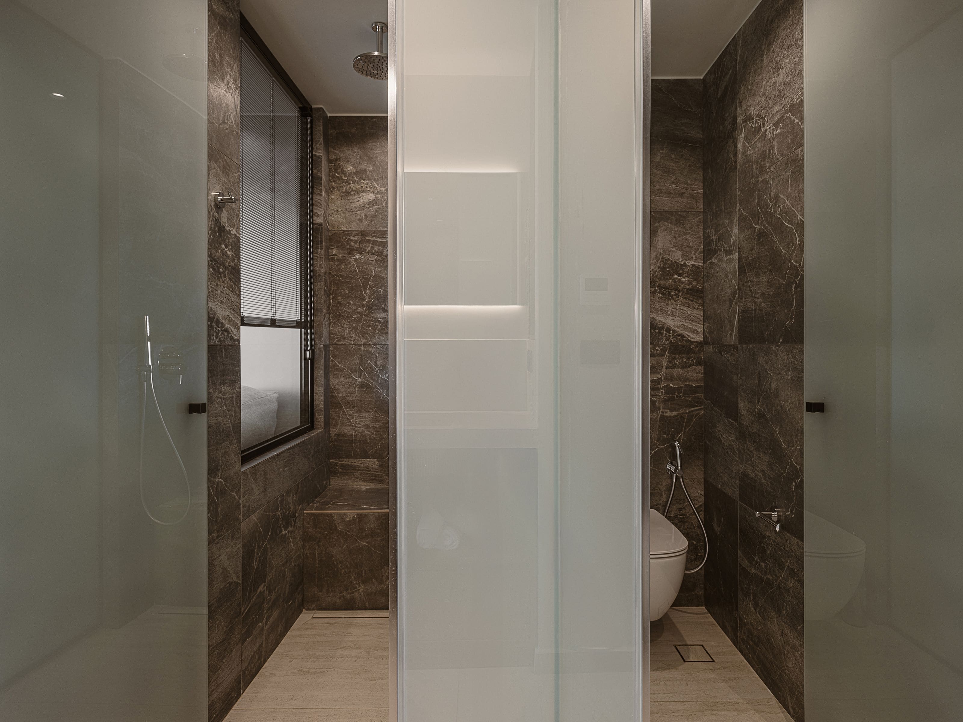 A modern bathroom with a glass-enclosed shower, a toilet, and a vanity with a mirror.