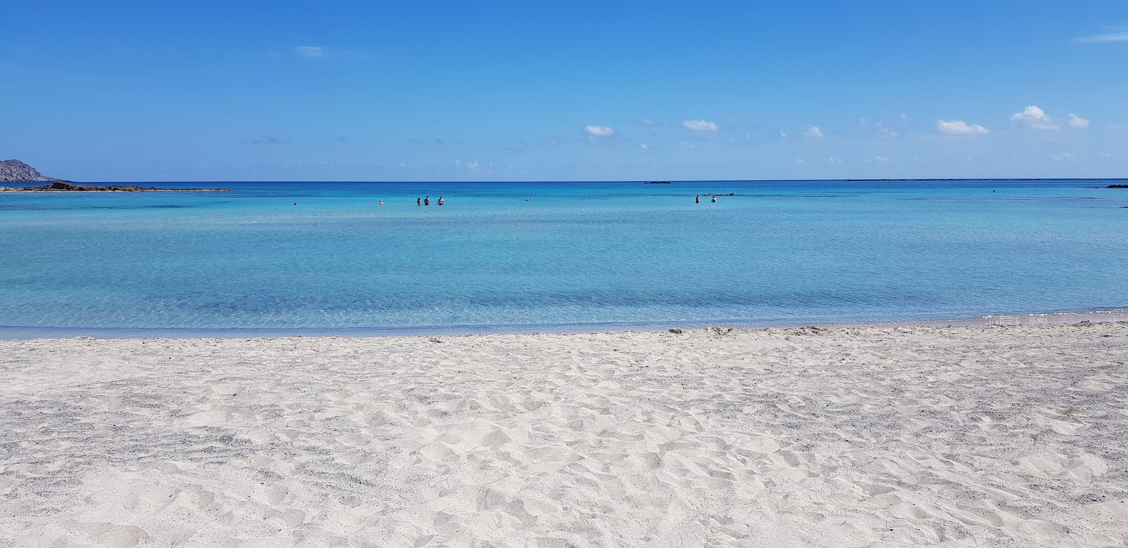 Una playa con agua turquesa cristalina y arena blanca.
