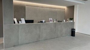 A reception desk with a modern design, featuring a flat surface and a lighted panel above. - Hotel Al Giardino (Treviso)