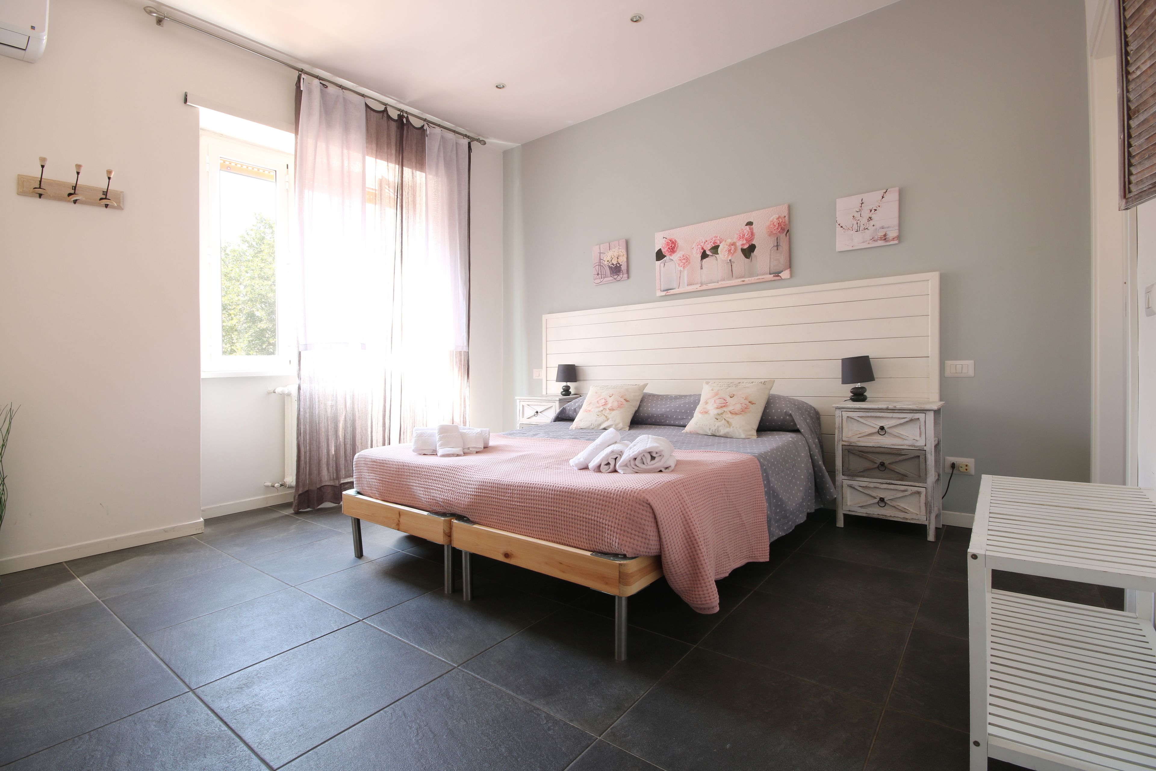 A bedroom with a bed, bedside tables, and artwork on the wall.