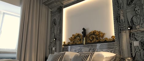 A hotel room with a bed, curtains, a mirror, and ornate wall decorations.
