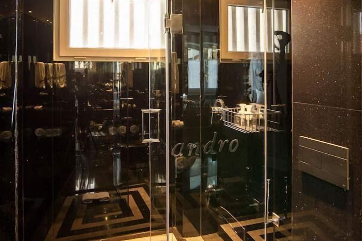 Ein modernes Interieur mit glänzenden Glasüren, einem geometrisch gemusterten Boden und einem sichtbaren 'andro'-Schild.