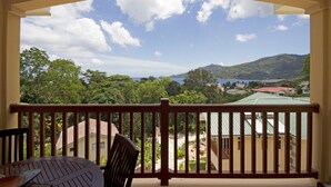 Un balcon donnant sur un paysage montagneux et un plan d’eau.
