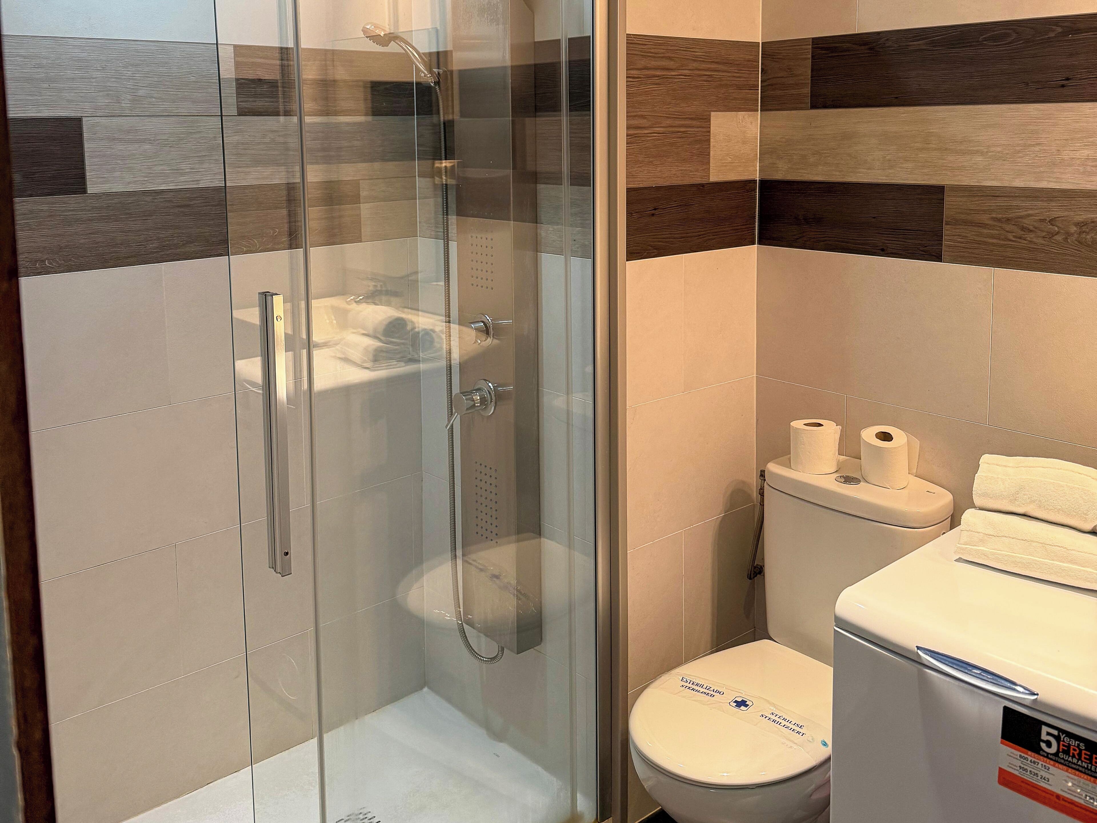 Eenvoudige studio | Badkamer | Een douche, handdoeken