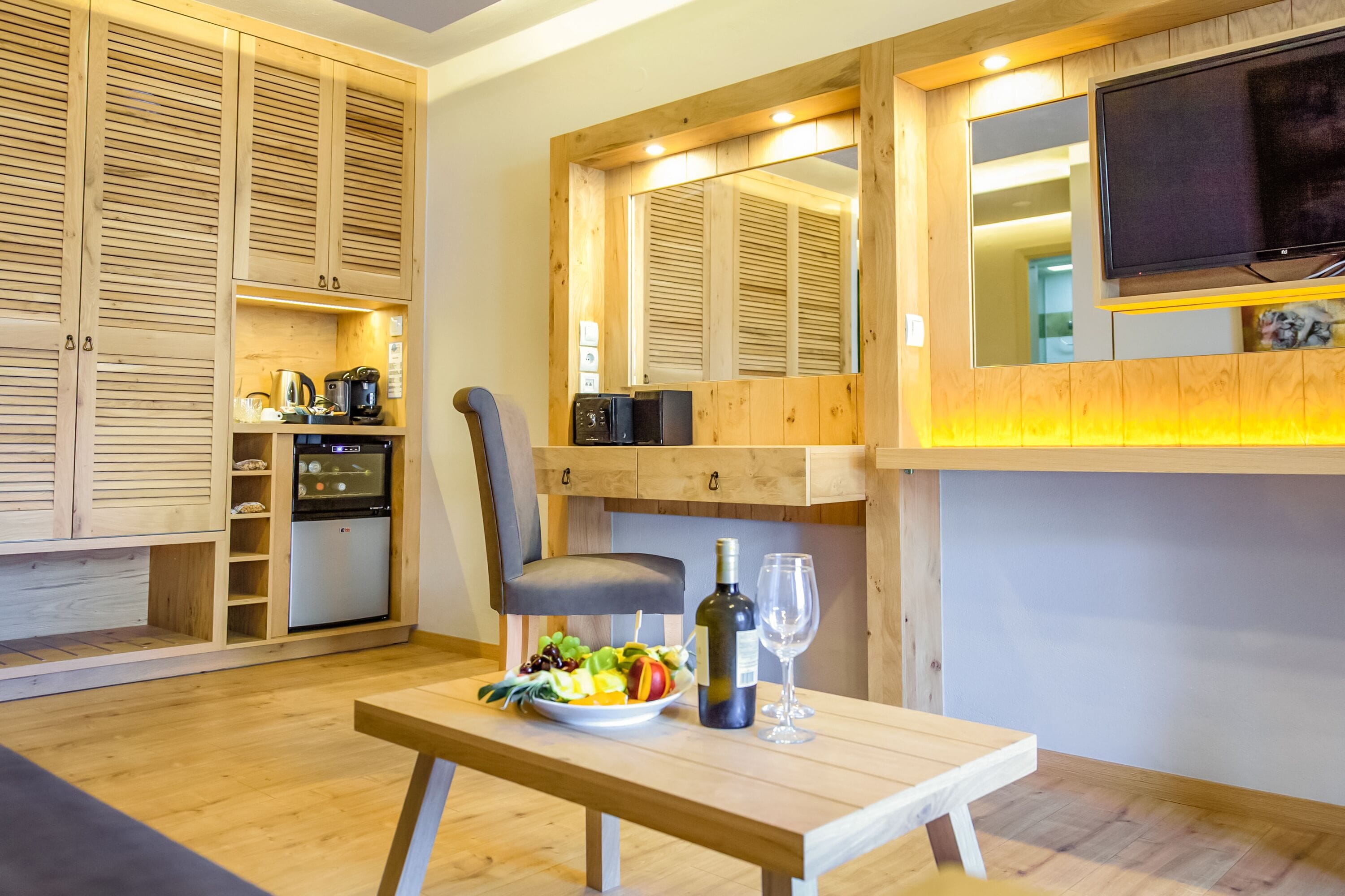 A modern kitchen with wooden cabinets, a built-in oven, and a dining area with a table set for two.
