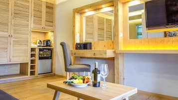 A modern kitchen with wooden cabinets, a built-in oven, and a dining area with a table set for two.
