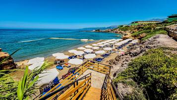 Praia particular, espreguiçadeiras, guarda-sóis, toalhas de praia