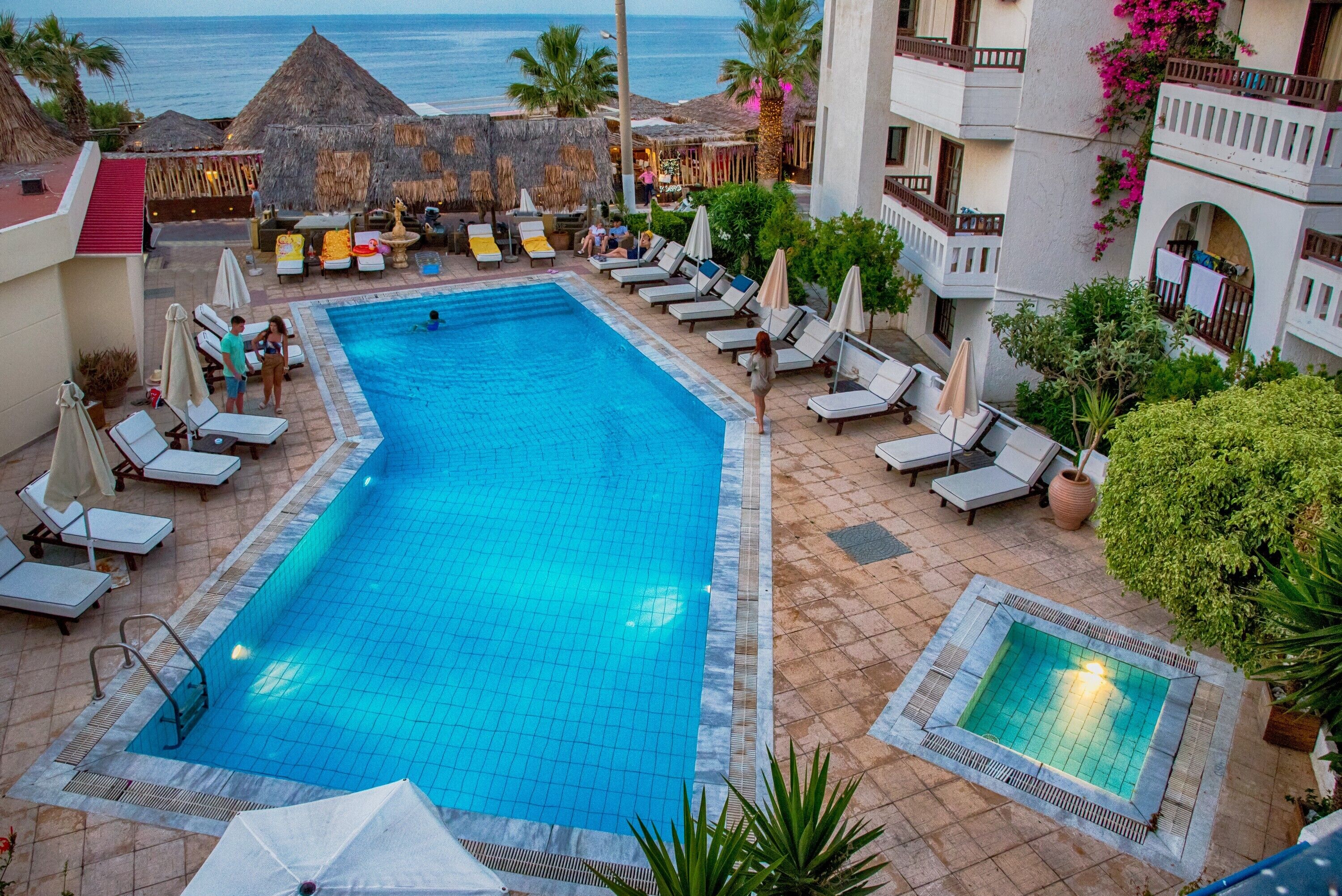 Una piscina al aire libre de temporada, sombrillas