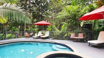 Una piscina al aire libre, sombrillas, tumbonas