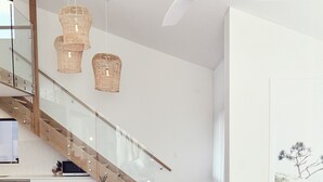 Ein modernes Wohnzimmer mit Treppe, Essbereich und einer Sofagarnitur.