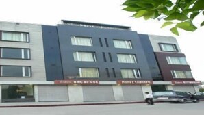 A hotel with a modern facade, multiple windows, and a ground floor with a restaurant and a bar. - Hotel Gulnar (New Delhi)