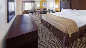 A hotel room with a large bed, a desk, a chair, and a television. - La Quinta Inn & Suites by Wyndham Floresville (Floresville)