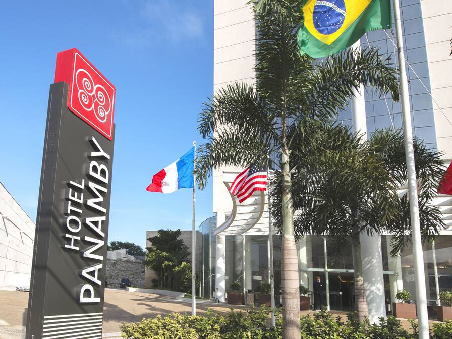 A hotel sign with the name "HOTEL PANAMBI" and flags of Brazil, France, and the USA.