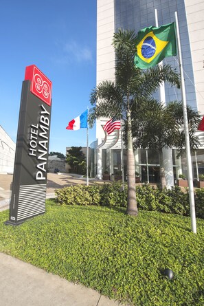 Segnaletica di un hotel con il nome 'HOTEL PANAMBI' e le bandiere del Brasile, Francia e degli Stati Uniti.