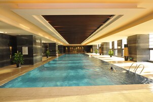 Una piscina techada, sillones reclinables de piscina