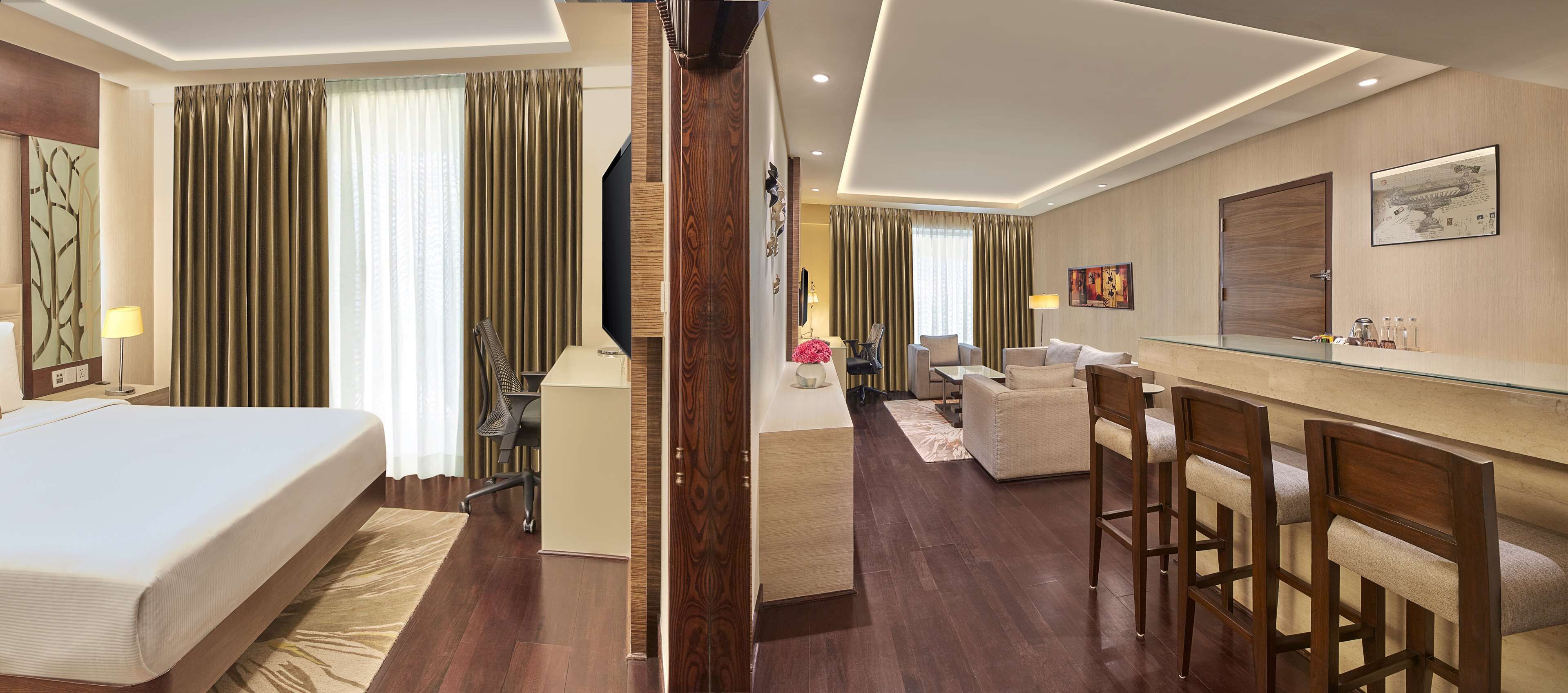 Een hotelkamer met een bed, bureau en zithoek.