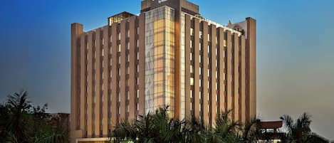 Um edifício alto e moderno de hotel com uma placa grande no topo que diz "DOUBLETREE by Hilton".