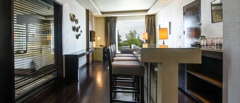 Un lobby moderno de hotel con zona de bar, asientos y vistas al exterior.