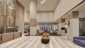 A spacious lobby with a reception desk, seating area, and a decorative floral arrangement. - DoubleTree by Hilton Gurugram Baani Square (Gurugram)