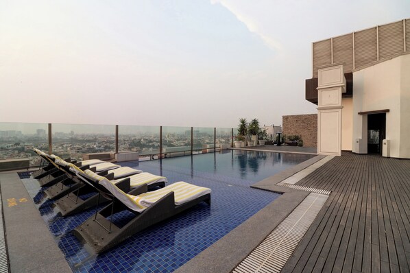 A rooftop infinity pool with lounge chairs and a city view. - DoubleTree by Hilton Gurugram Baani Square (Gurugram)