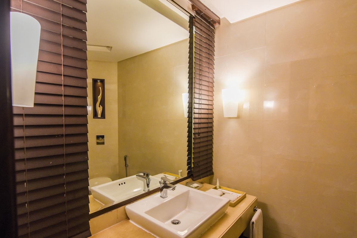 Un baño con dos lavamanos, un espejo y un perchero para toallas.