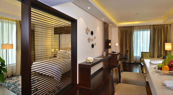 A hotel lobby with a reception desk, seating area, and a large mirror. - DoubleTree by Hilton Gurugram Baani Square (Gurugram)