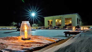 Una terraza en la azotea con velas, un edificio al fondo y un cielo nocturno despejado.