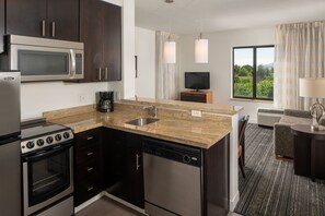 A modern kitchen with a microwave, stove, dishwasher, and granite countertop. - TownePlace Suites by Marriott Vernal (Vernal)