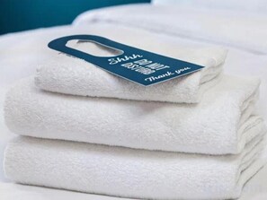 A stack of white towels with a tag that reads 'Shhh DO NOT DISTURB Thank you.' - Travelodgellanelli Cross Hands (Llanelli)