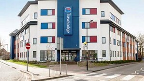 A Travelodge hotel with a modern design, featuring a prominent blue and white color scheme, multiple windows, and a visible entrance. - Travelodge Woking Central (Woking)