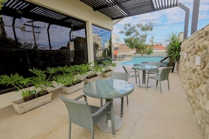 Una piscina al aire libre, sillones reclinables de piscina