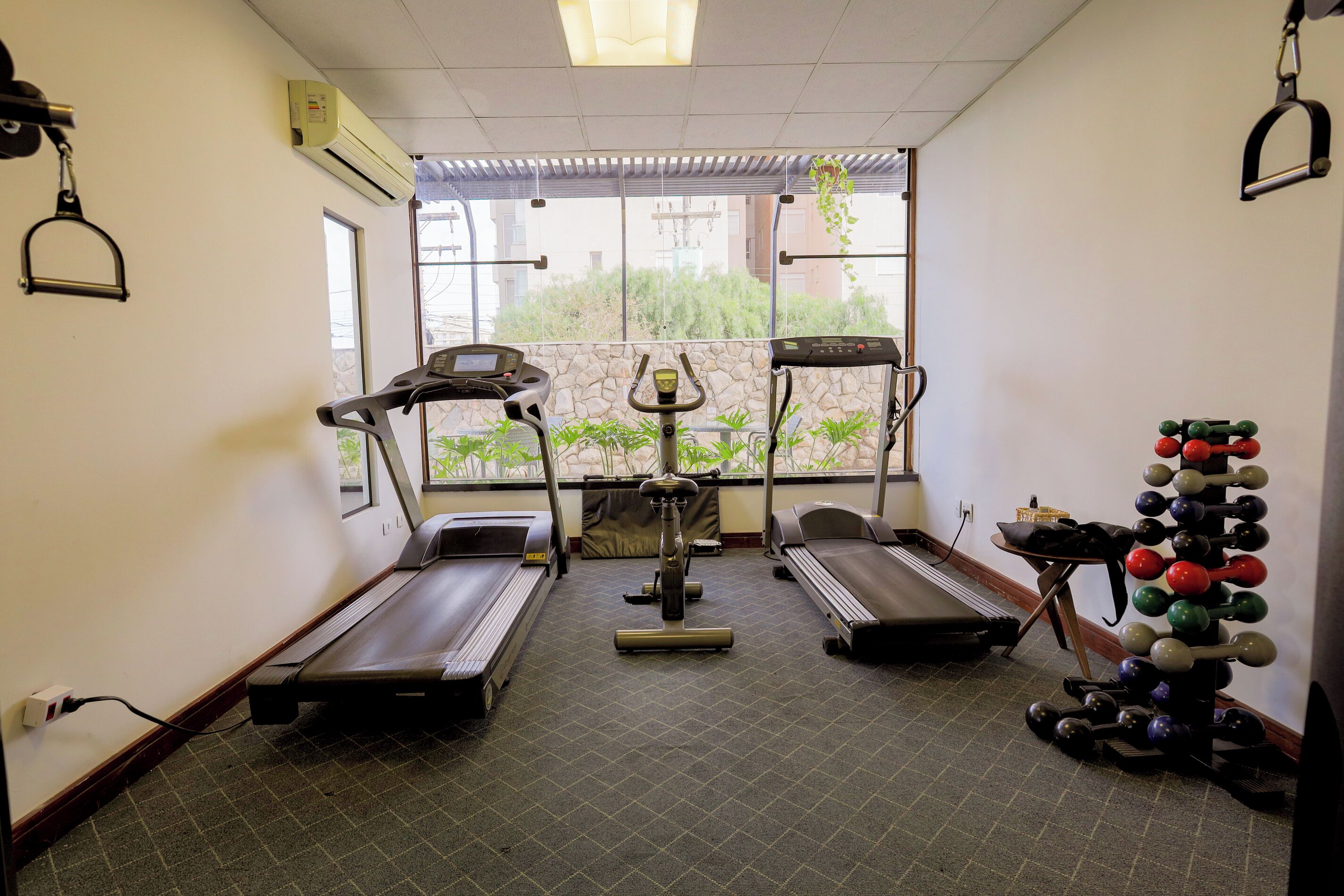A gym with treadmills, an elliptical, and a weight rack.
