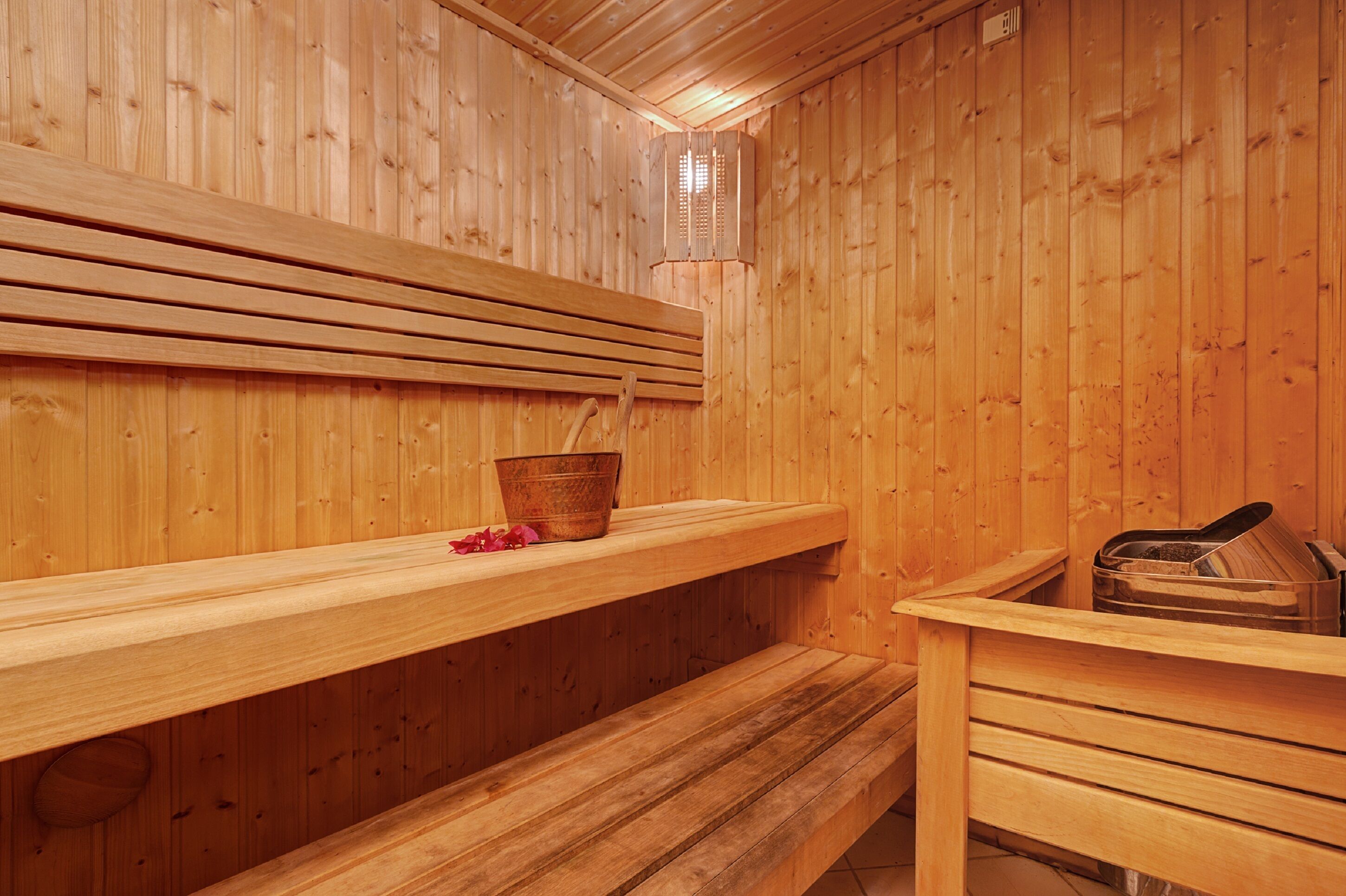 A wooden sauna with benches and a wooden shelf.