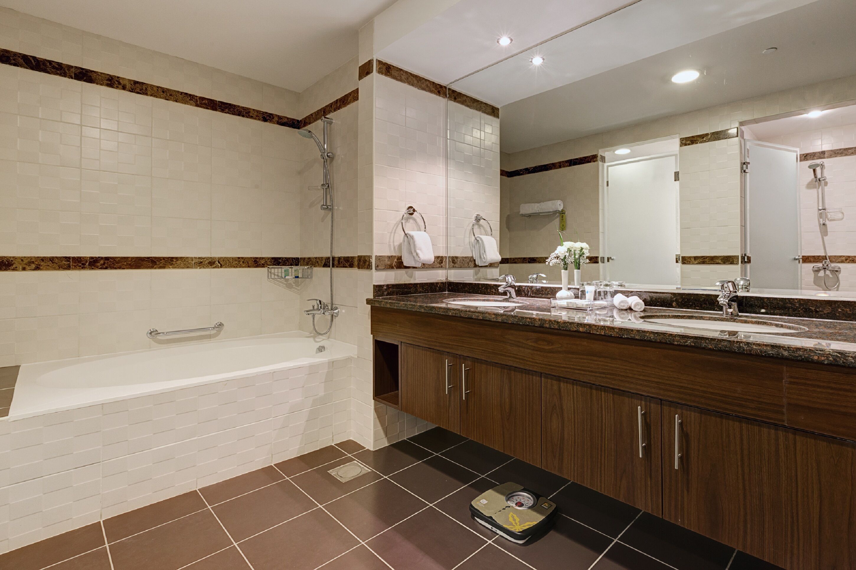 A modern bathroom with a large bathtub, a double sink vanity, and a large mirror.