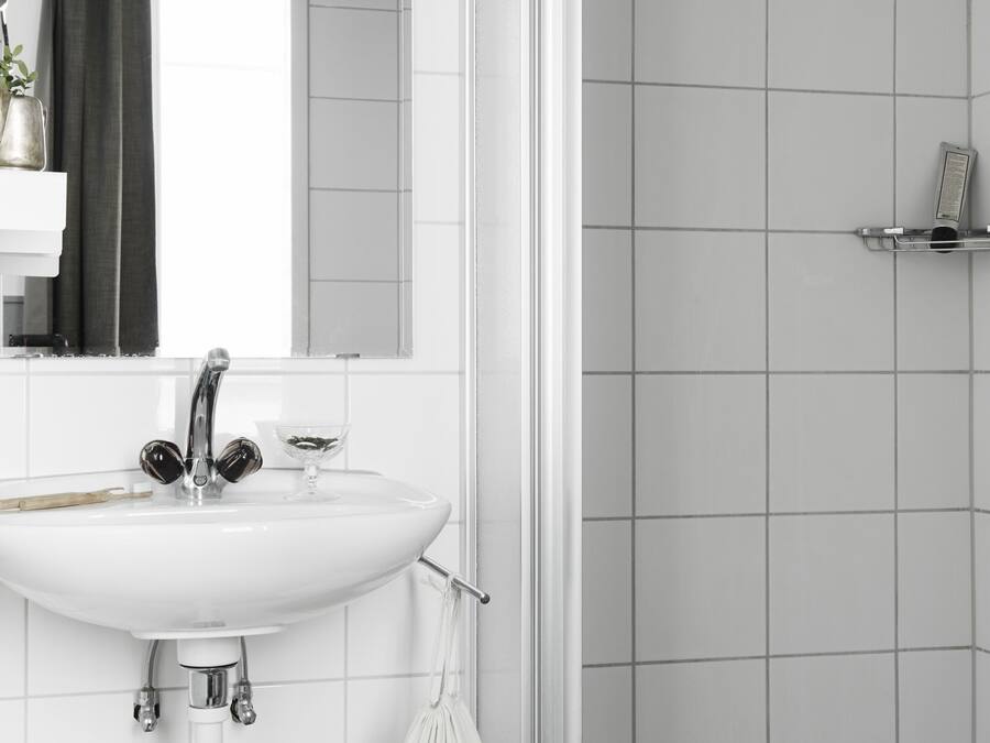 A bathroom with a white sink, mirror, and towel rack.