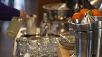 A bar area with a cocktail shaker, glasses, and a candle.