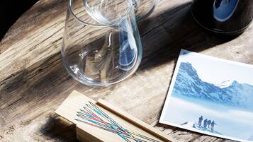 Una mesa de madera con dos vasos transparentes, una caja de cerillas y una fotografía.