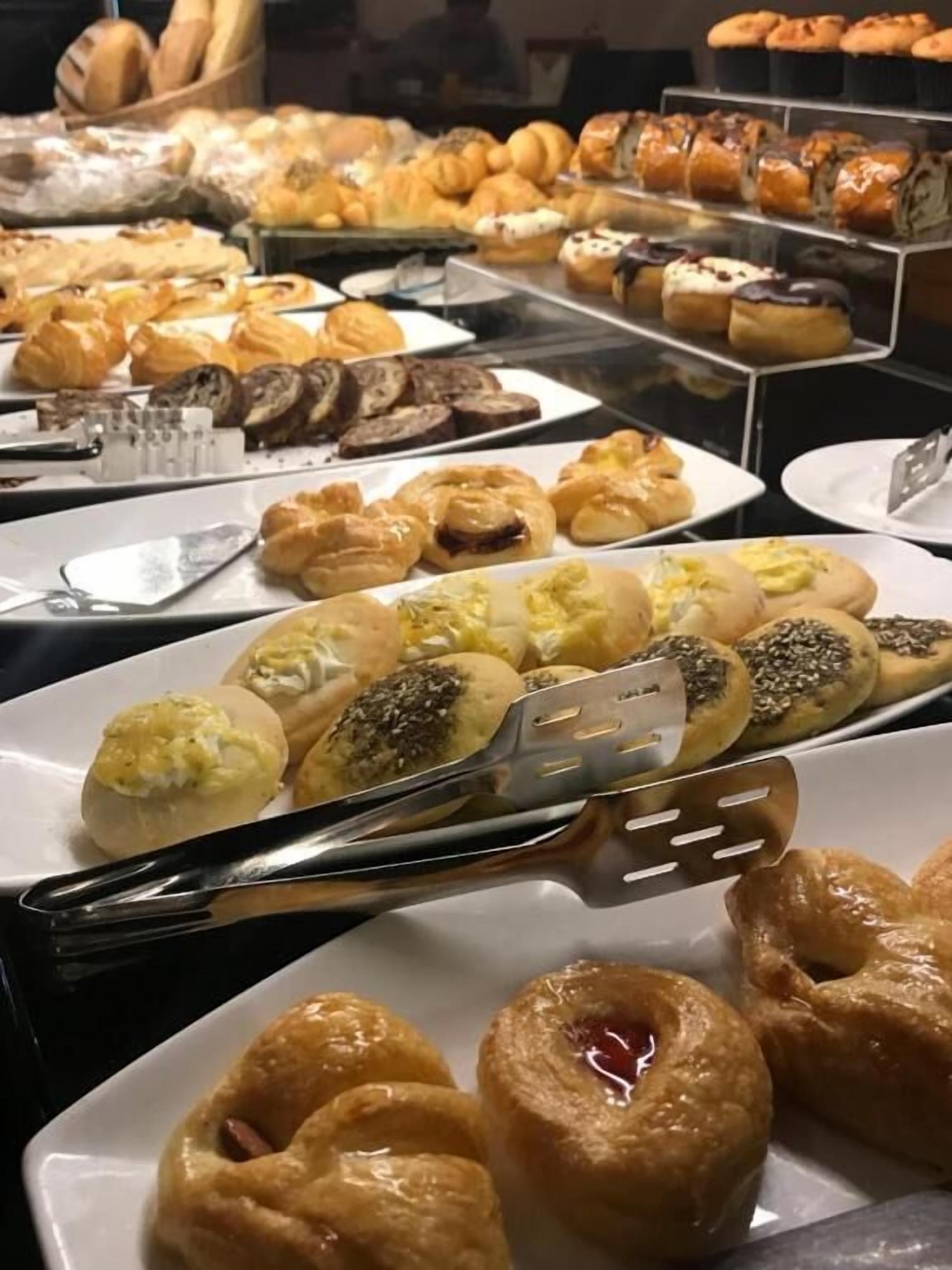 Buffet com diversos doces e produtos de pastelaria.