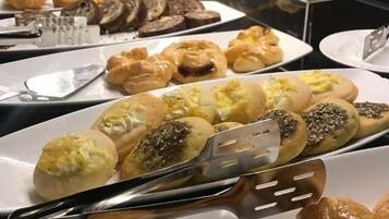 Buffet com diversos doces e produtos de pastelaria.