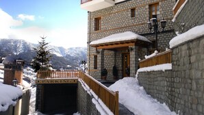A stone building with a sign reading "APXONTIKO METEOBOY" and a "PARKING" sign at the entrance. - Archontiko Metsovou Boutique Hotel (Metsovo)