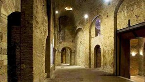 A corridor with stone walls and arched doorways, leading to a central open space. - Anna Boccali Resort (Corciano)