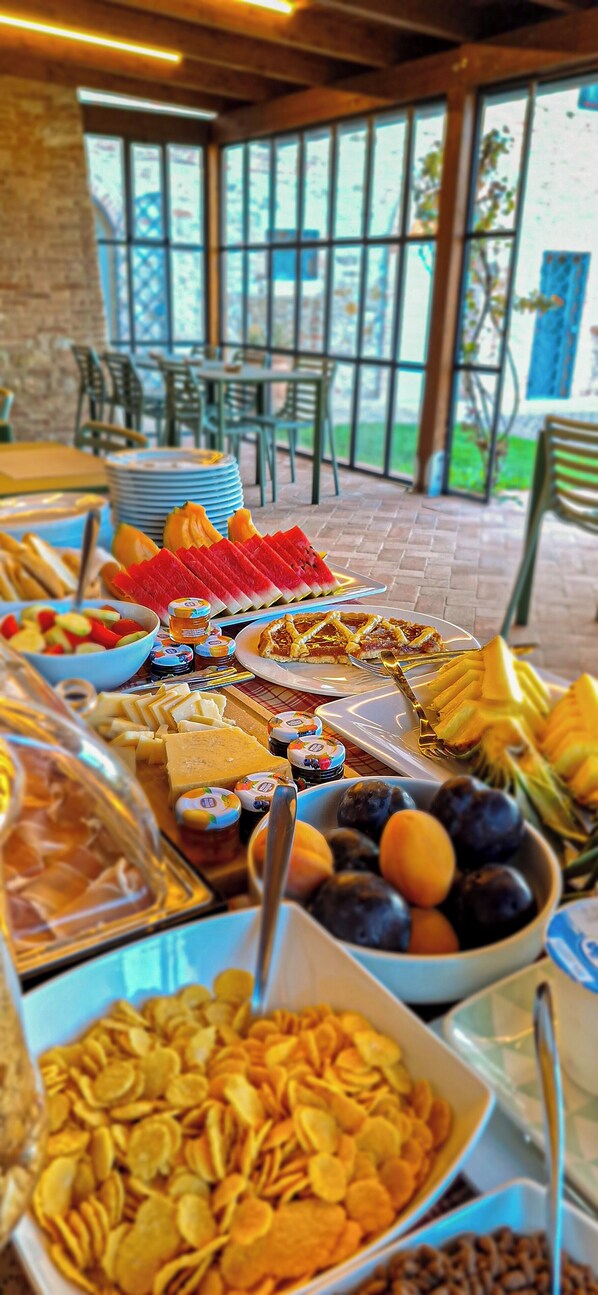 A buffet table with various food items including fruits, cheeses, and cereals. - Anna Boccali Resort (Corciano)