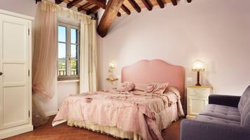 A bedroom with a bed, a chair, a nightstand, and a window with curtains.