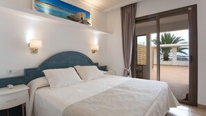 Une chambre d’hôtel avec un lit, des tables de chevet, un tableau et une vue sur l’extérieur.