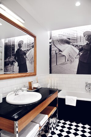 A modern bathroom with a black and white checkered floor, a white sink, a black countertop, and a large mirror. - Jovi Apartments (Sopot)