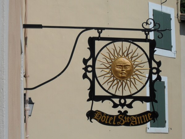 Un letrero montado en la pared con un motivo de sol y el texto "Hotel Steamerme".