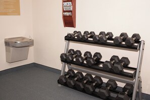A gym with a rack of dumbbells and a wall-mounted sign. - Candlewood Suites Logan by IHG (Logan)