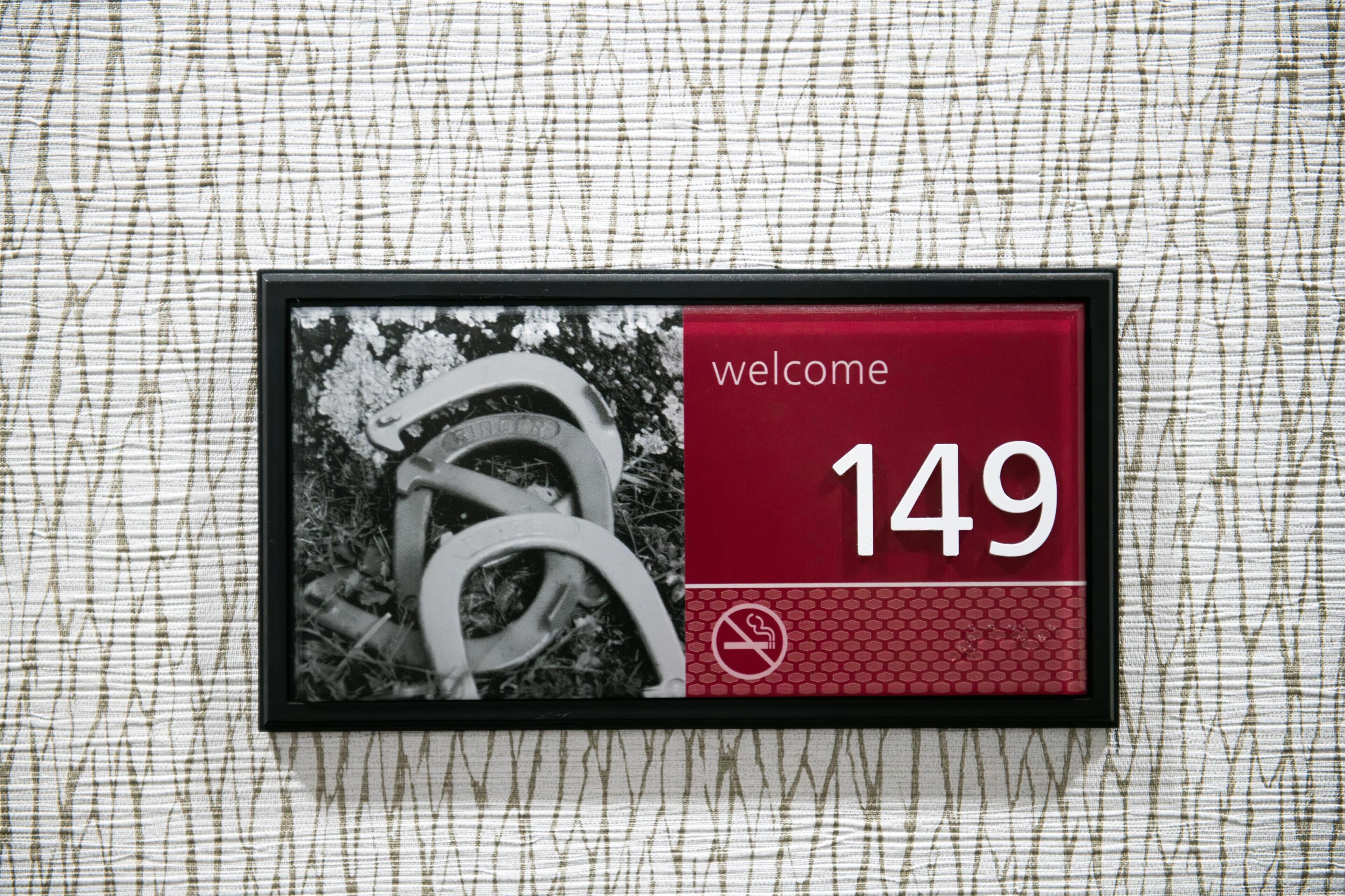 A welcome sign with the number 149, a no-smoking symbol, and a photo of a horse.